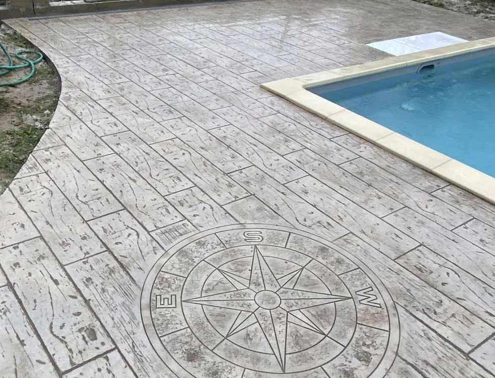 Une photo d’une piscine avec une grande terrasse en béton estampé